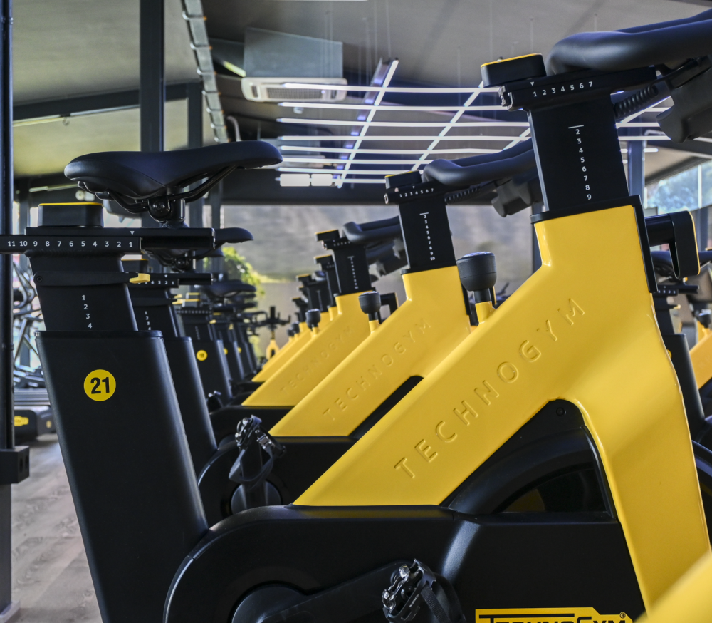 Zona de spinning con bicicletas indoor en sala de clases dirigidas